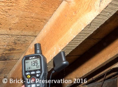 A moisture meter applied to a roof timber infested by Common Furniture Beetle